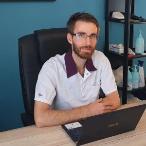 Portrait de Olivier Benoit, ostéopathe D.O., à son bureau de consultation au cabinet d'ostéopathie de Bischwiller.